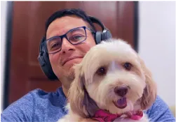 A man wearing headphones holding a dog