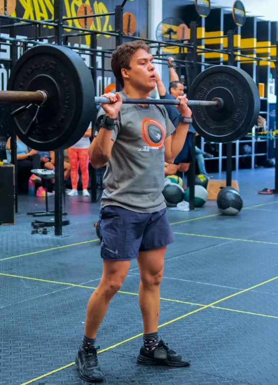 A man holding a barbell in a gym